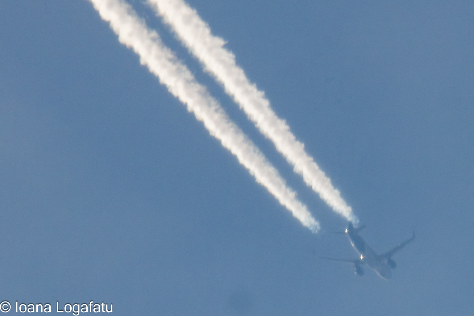 Jet trails streaking across a clear blue sky